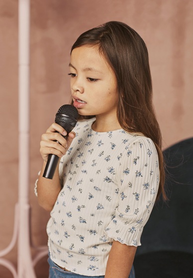 little girl learning how sing home with mic